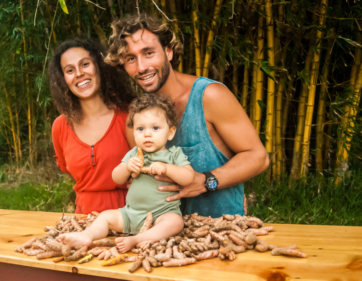 founders of Aina culture with child showing turmeric on their first year of farming