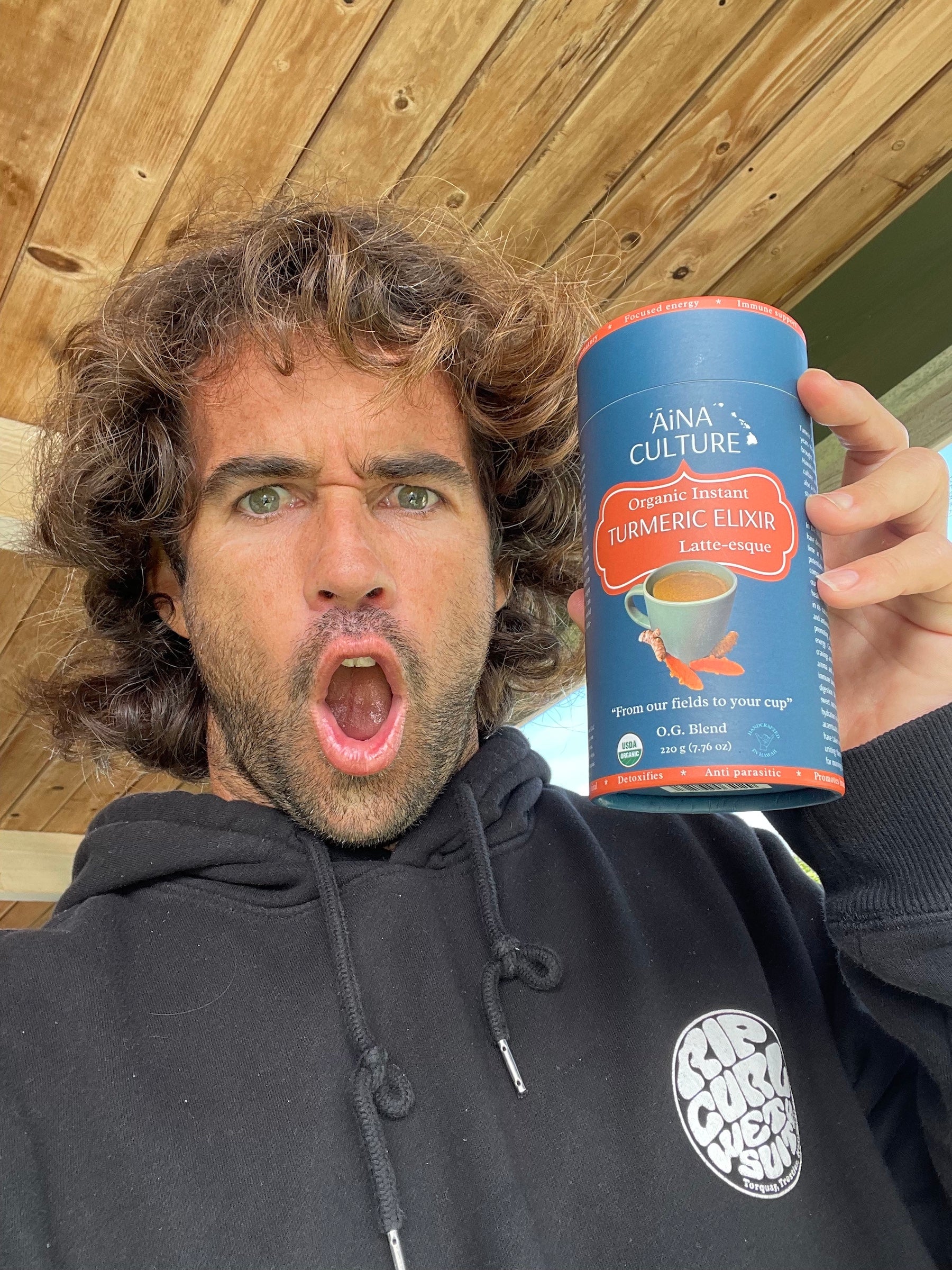 Mason Ho holding AiNA CULTURE turmeric elexir